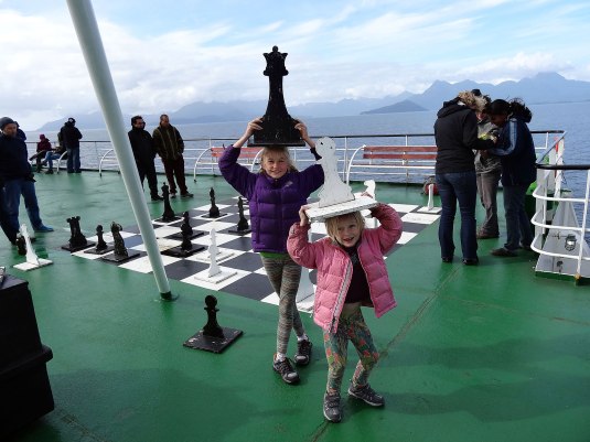 Girls get helpful with the game on chess on deck!